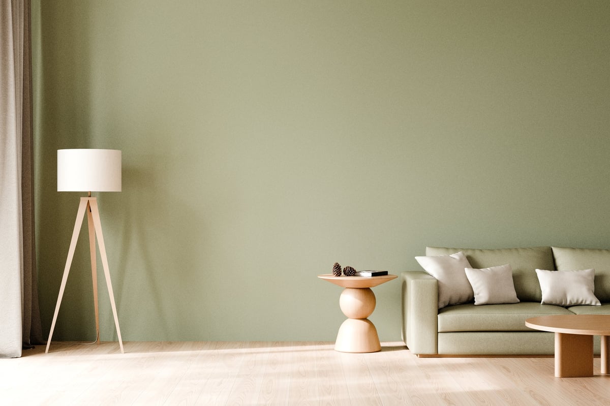 Modern living room with sage green sofa and warm neutral colors